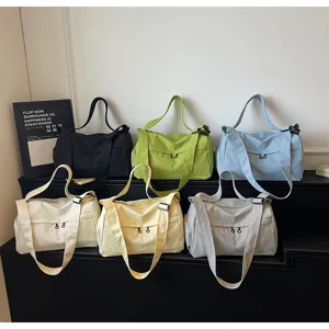 Détail de sacs de voyage de sport colorés et de grande capacité en toile disposés proprement.