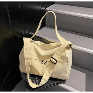 Vue détaillée du grand sac de voyage en toile jaune clair avec double sangle réglable.