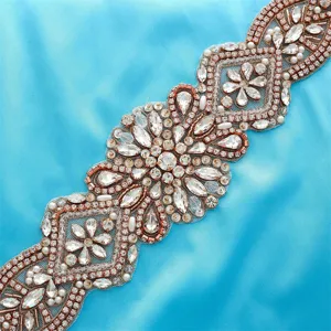 Close-up of sparkling bridal rhinestone applique, handmade crystal belt detail for wedding gowns.