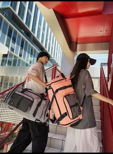 Outdoor lifestyle detail shot showing large capacity travel duffel bags worn by models on stairs.