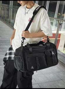 Detailed view of large capacity black travel duffel bag with multi pockets and shoulder strap.