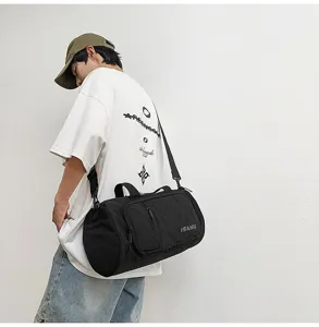 Detailed shot of a black cylindrical travel duffel bag with shoulder strap and carry handle.