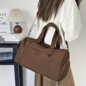 Vue détaillée du sac de voyage marron avec tissu résistant et poche latérale zippée.