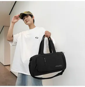 Black travel duffel bag with adjustable shoulder strap, sporty fitness bag detailed shot.
