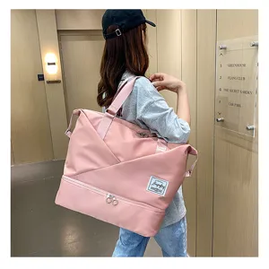 Close-up detail of the pink travel duffel bag showing large capacity and bottom shoe compartment.
