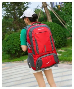 Détail du sac à dos de randonnée en tissu durable rouge et gris, poches pratiques et bretelles.