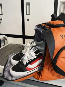 Large capacity orange travel duffel bag with shoe compartment for gym and outdoor sports.