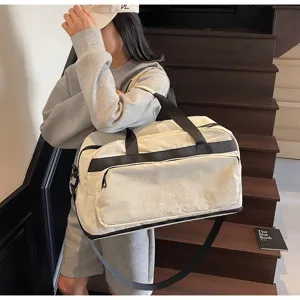 Dettaglio borsa da viaggio in tela grande capacità, scena lifestyle su scala di legno.