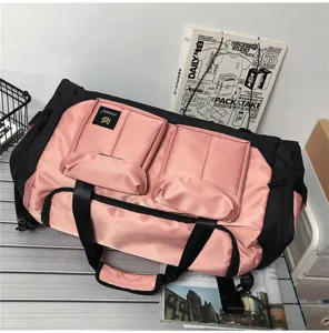 Large capacity pink and black travel duffel bag with front pockets and durable shoulder strap.