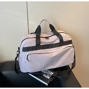 Dettaglio della grande borsa da viaggio con tessuto impermeabile resistente e tasca frontale.