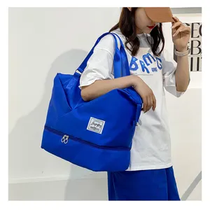 Detail shot of blue large capacity travel duffel bag with wet dry separation compartment.