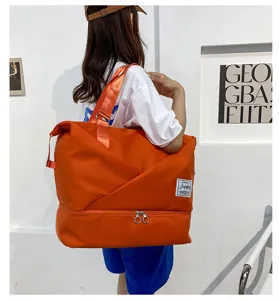 Detailed view of large capacity orange travel duffel bag with bottom zip wet dry compartment.