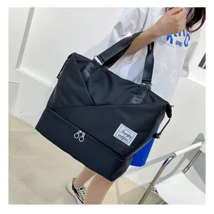 Detail view of black travel duffel bag with bottom wet dry compartment and sturdy tote handles.