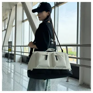 Canvas travel duffel bag with dual front pockets in beige and black, detailed view.