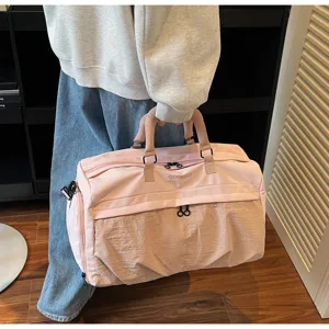 Detailansicht der großen rosa Reisetasche mit kontrastierendem Boden und stabilen Griffen.