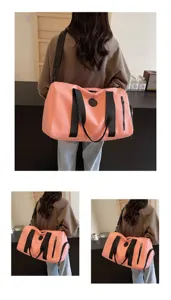 Vue détaillée du grand sac de voyage rose avec poignées et bandoulière robustes et pratiques.