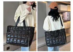 Detail view of the black quilted puffer tote bag, showing side zipper pocket and waterproof fabric.