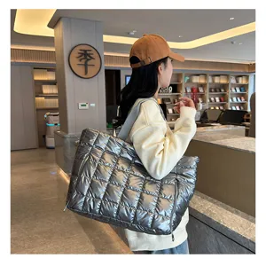 Stylish quilted metallic gym tote bag lifestyle detail shot showcasing wearing effect in lobby.
