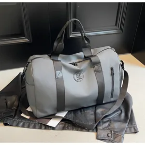 Détail de sac de voyage gris, grand sac de sport étanche de grande capacité avec bandoulière.