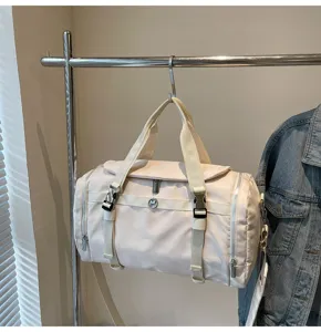 Beige travel duffel bag hanging on a rack, showcasing the detailed straps and durable fabric.