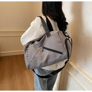 Detailed view of large capacity grey travel duffel bag with shoulder strap for fitness.