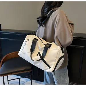 Detailed view of the large capacity white travel duffel bag with black straps and side pocket.