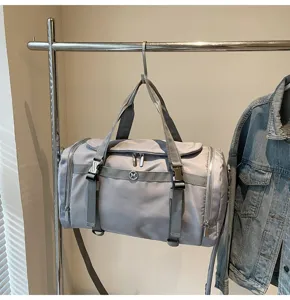 Detail view of a grey nylon travel gym duffel bag with dry wet separation and straps.