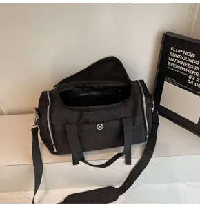 Black large capacity travel gym duffel bag with wet dry separation and shoulder strap.