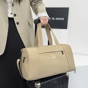 Détails du sac de voyage léger montrant un tissu kaki durable et une poignée pratique.