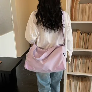Detail view of the large capacity purple duffel bag showing strap and soft fabric.