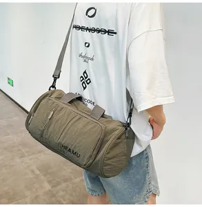 Green travel duffel bag worn by model, featuring handy strap for sports and fitness use.