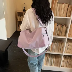 Detail view of a light purple gym duffel bag worn by a model in a cozy indoor library setting.