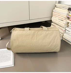 Close-up view of the beige cylindrical travel duffel bag showing its lightweight fabric and shape.