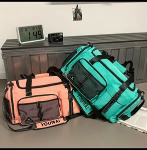 Detailed view of large capacity travel duffel bags in pink and turquoise with mesh pockets.