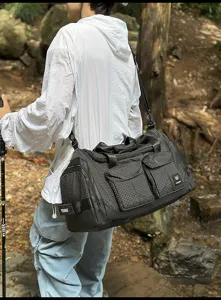 Outdoor multi-functional fitness gym duffel bag with grid pattern, detail view in nature.