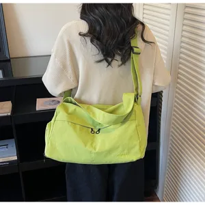 Grand sac de voyage et de sport en toile pour femmes, bandoulière réglable et grand espace.