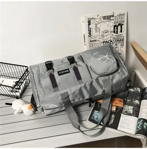 Closeup of gray travel duffel bag featuring multi-pocket design, durable straps and sport style.