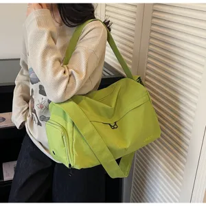 Vue de detail du sac de sport bandouliere vert vif avec sangle et texture de tissu.