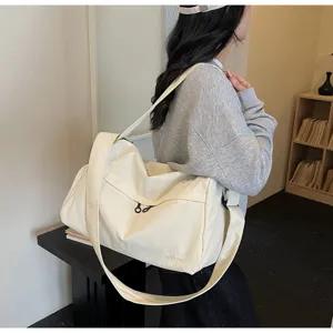 Vue détaillée d'un grand sac de voyage en toile beige idéal pour vos déplacements.