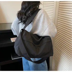 Grand sac de sport noir avec sangle large, idéal pour le fitness, les voyages et la natation.