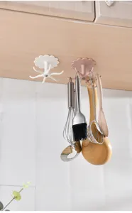 Kitchen rotating wall-mounted hook adhesive multi-claw storage rack for hanging utensils.