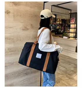 Grand sac de voyage souple pour femme, sac de sport léger et pratique avec poignées solides.