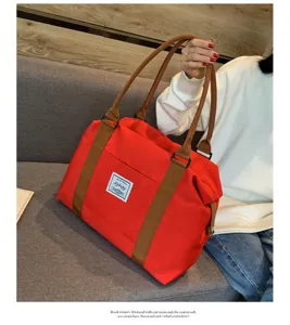 Détail du sac de voyage rouge, grand sac week-end avec anses marron dans une scène.