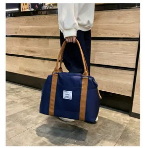 Grand sac de voyage grande capacité pour femmes et hommes, sac léger avec poignées marron.