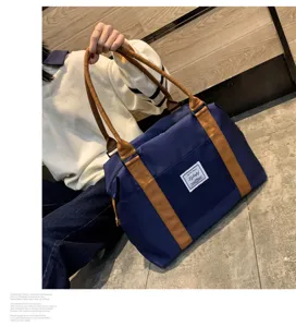 Vue detaillee du grand sac de voyage bleu avec des poignees marron et une fermeture zippee.