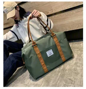 Gros plan d'un grand sac de voyage en toile verte avec des poignées marron, vue de détail.