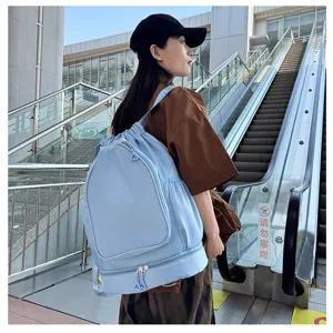 Detailed scene shot of the light blue drawstring sports backpack with bottom compartment, worn outdoors.