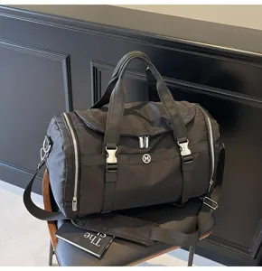 Large capacity black nylon travel duffel bag, versatile gym fitness bag with sturdy straps.