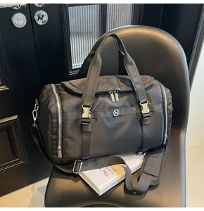 Black nylon travel gym duffel bag detail showcasing side zippers and sturdy top handles.