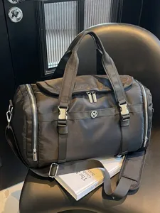 Black lightweight travel duffel bag with large capacity, durable nylon gym bag with shoulder strap.